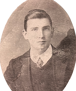 Posed sepia photo, head and shoulders of young Matthew Kinsella in pinned shirt collar and tie, waistcoat and jacket.